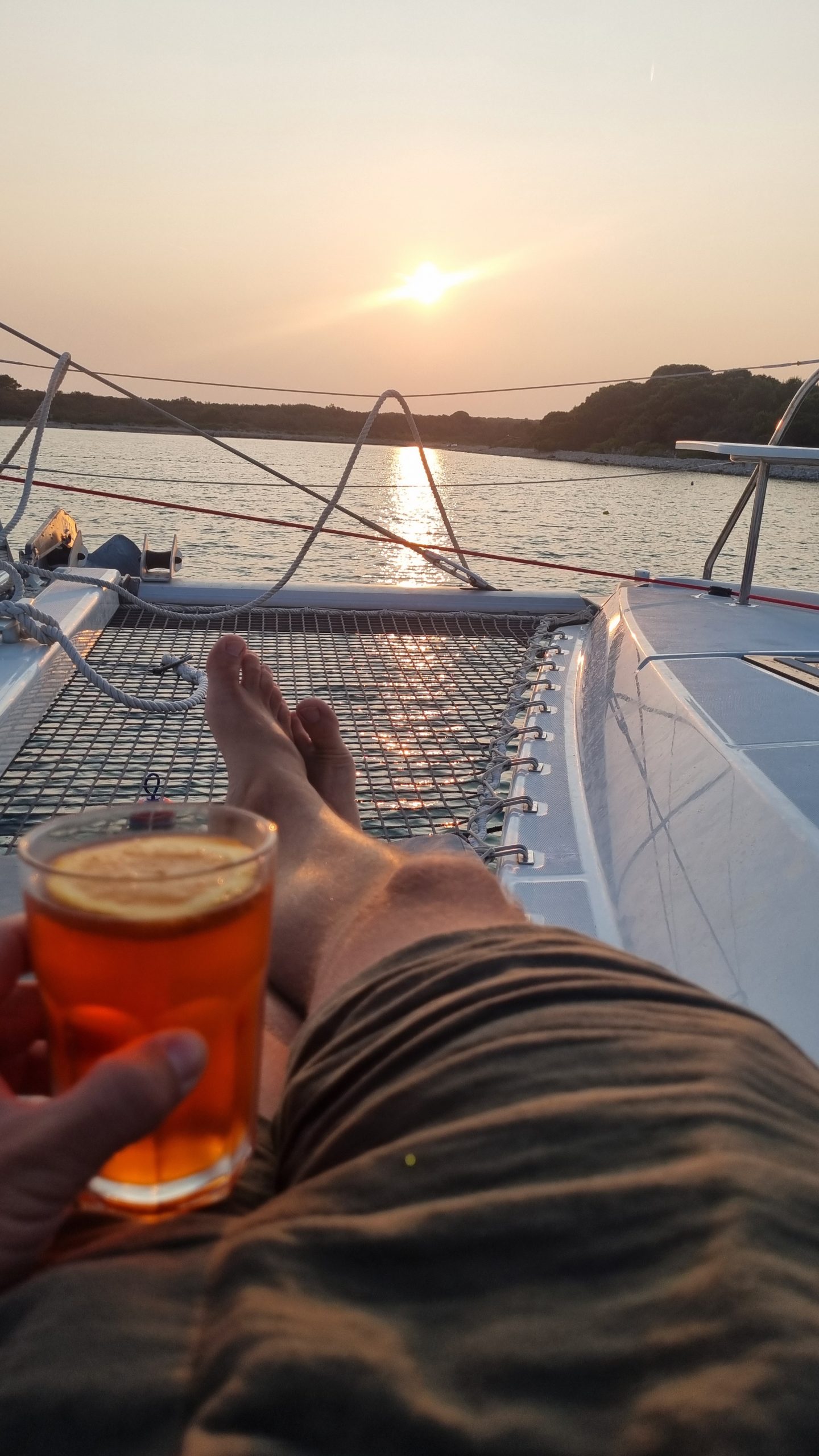 Entspannter Sonnenuntergang an Deck vor der kroatischen Küste, Getränk in der Hand